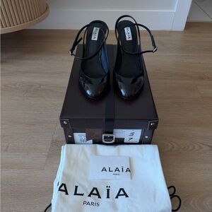Alaia black patent slingback pumps